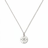 A True North Engraved Compass Pendant Necklace by Skōsh Jewelry, featuring a round compass medallion engraved with a compass rose on a fine sterling silver chain, displayed against a white background.