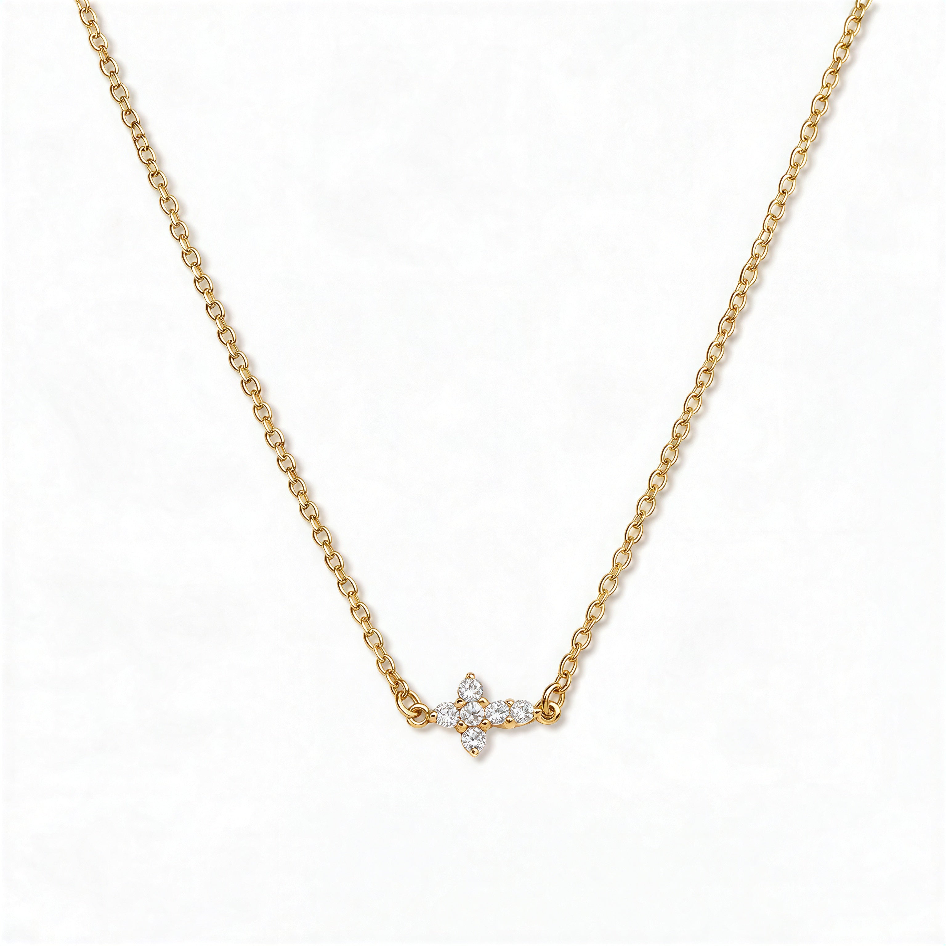 A Steadfast Grace Sideways Cross with White Cubic Zirconia Necklace by Skōsh Jewelry, featuring a small sideways cross accented with clear stones on a fine gold chain, displayed against a white background.