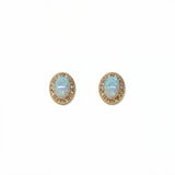 A pair of Ethereal Opal with White Cubic Zirconia Halo Earrings by Skōsh Jewelry, featuring oval iridescent opals framed by halos of small clear stones in gold, displayed against a white background.