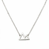 A Mountains and Valleys Necklace by Skōsh Jewelry, featuring an open outline of two mountain peaks set on a fine sterling silver chain, displayed against a white background.