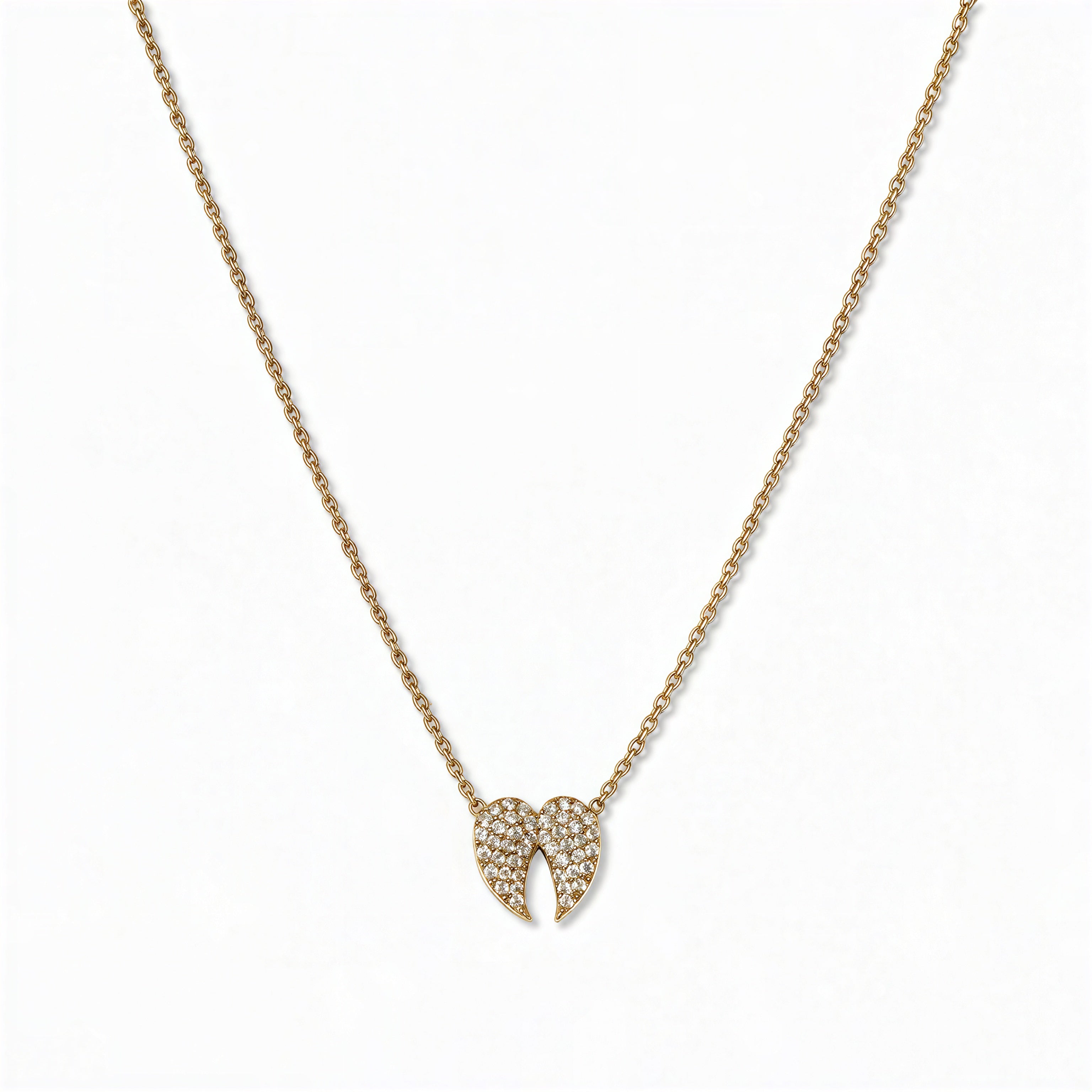 A Celestial Pavé White Cubic Zirconia Wings Necklace by Skōsh Jewelry, featuring a pair of angel wings covered in small clear pavé stones on a fine gold chain, displayed against a white background.