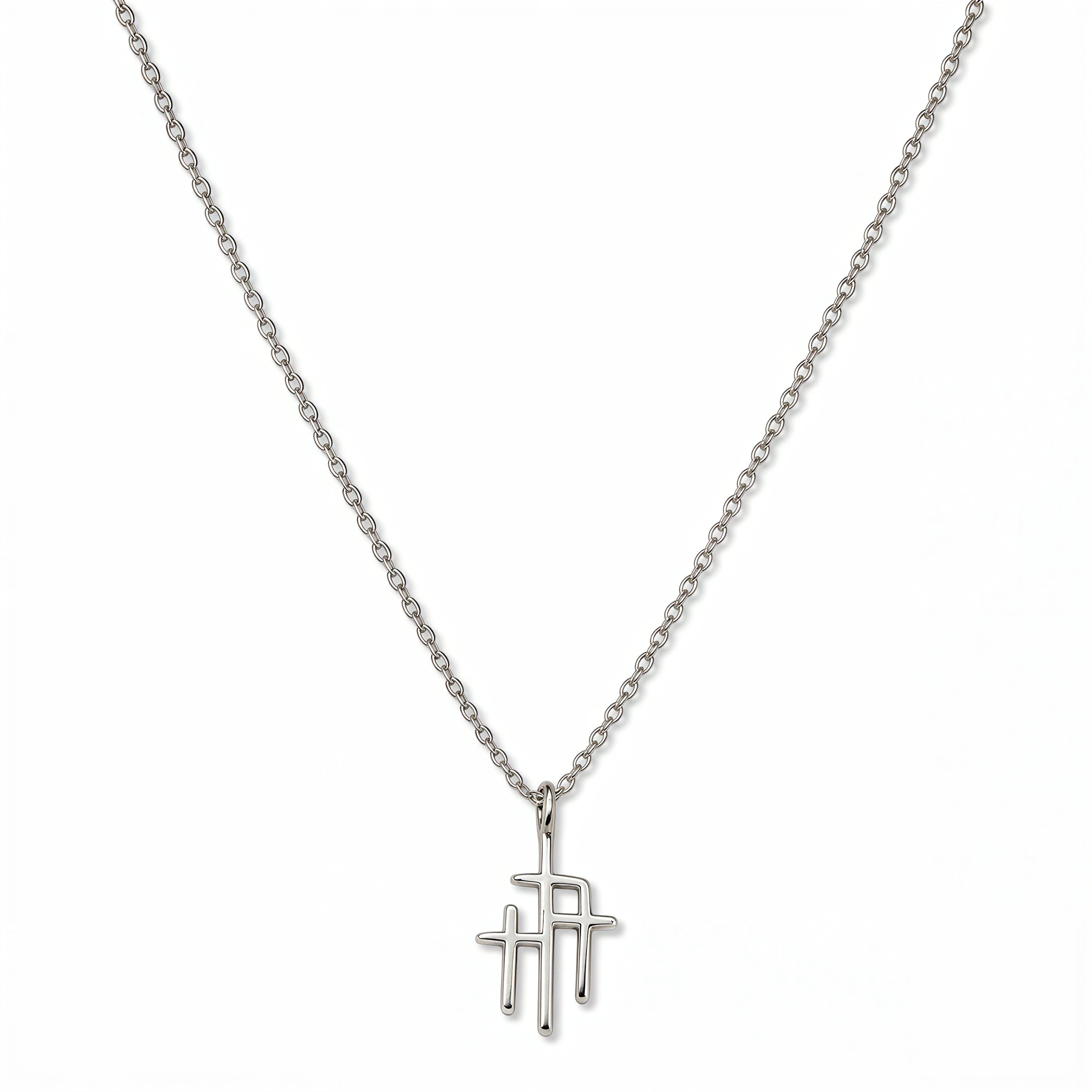A Trinity Triple Cross Pendant Necklace by Skōsh Jewelry, featuring three slim crosses joined side by side, the center one tallest, on a fine sterling silver chain, displayed against a white background.