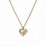 A Heart, Sun & Moon with White Cubic Zirconia Pendant Necklace by Skōsh Jewelry, featuring an open heart framing a sun and crescent moon with clear stone accents on a fine gold chain, displayed against a white background.