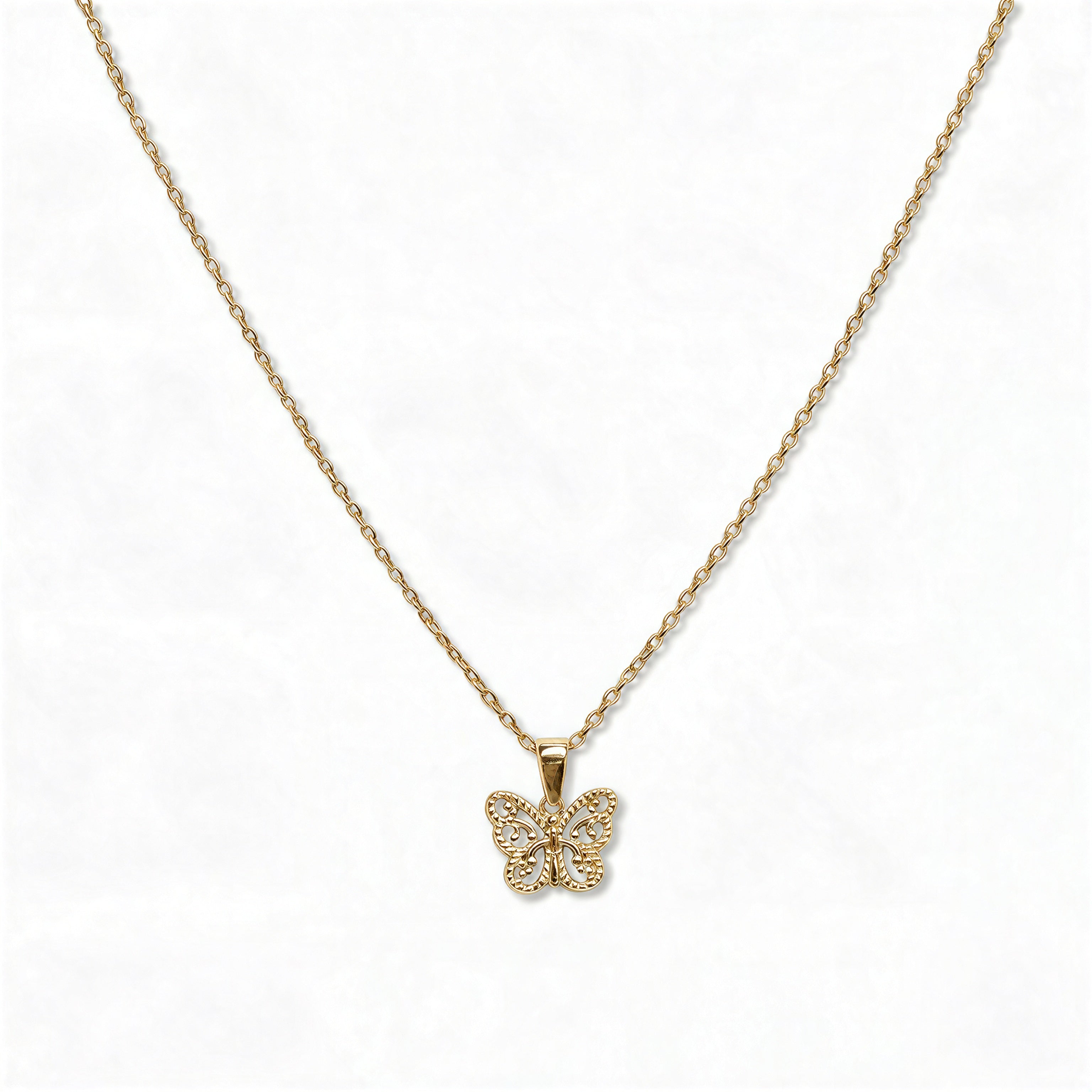 A Filigree Butterfly Pendant Necklace by Skōsh Jewelry, featuring a small butterfly with lacy filigree wings on a fine gold chain, displayed against a white background.