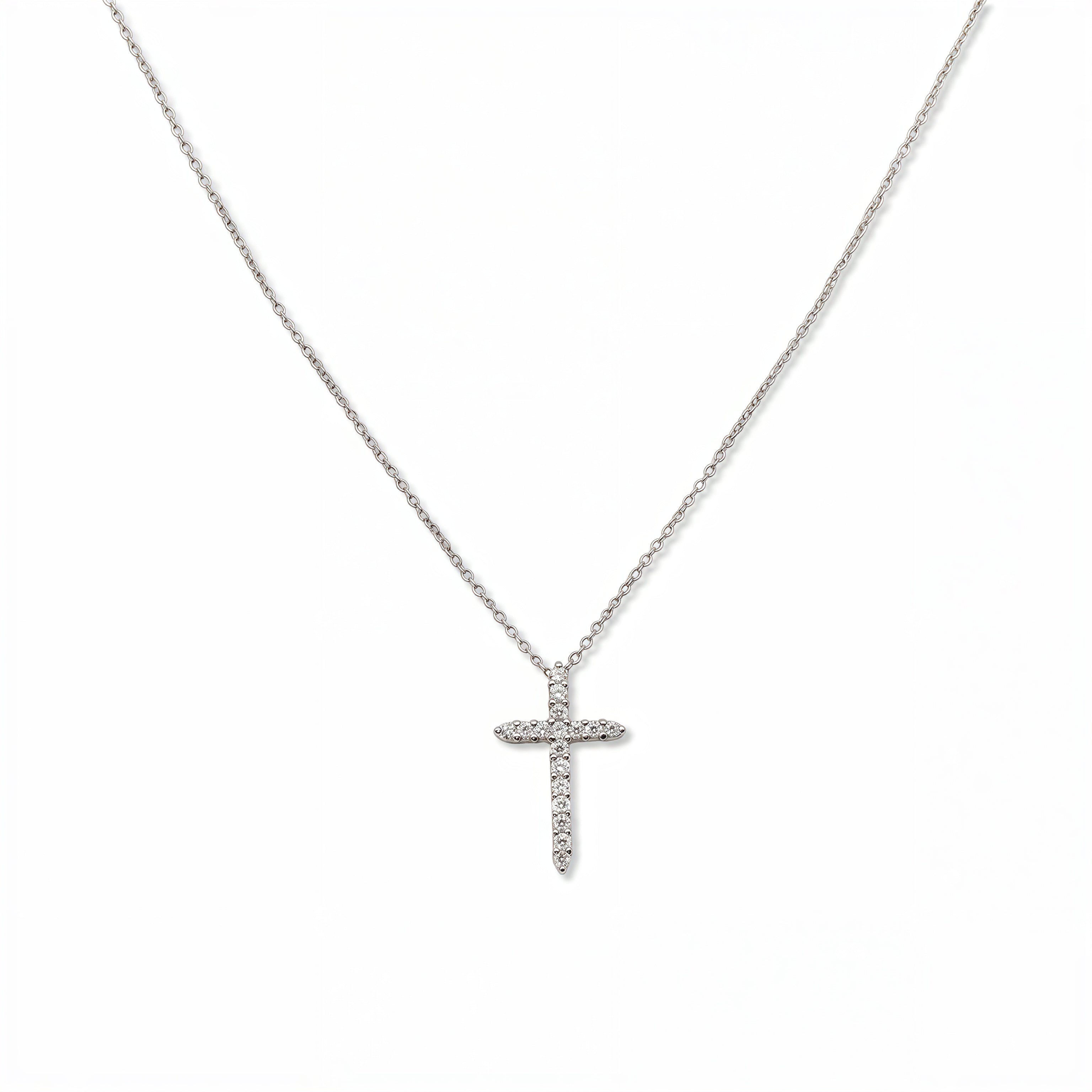 A Classic Light White Cubic Zirconia Cross Necklace by Skōsh Jewelry, featuring a classic cross lined with small clear stones on a fine sterling silver chain, displayed against a white background.
