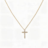 A Classic Light White Cubic Zirconia Cross Necklace by Skōsh Jewelry, featuring a classic cross lined with small clear stones on a fine gold chain, displayed against a white background.