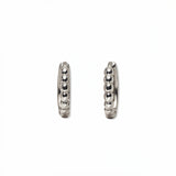 A pair of Beaded Huggie Hoop Earrings by Skōsh Jewelry, featuring small sterling silver huggie hoops with a beaded texture, displayed against a white background.