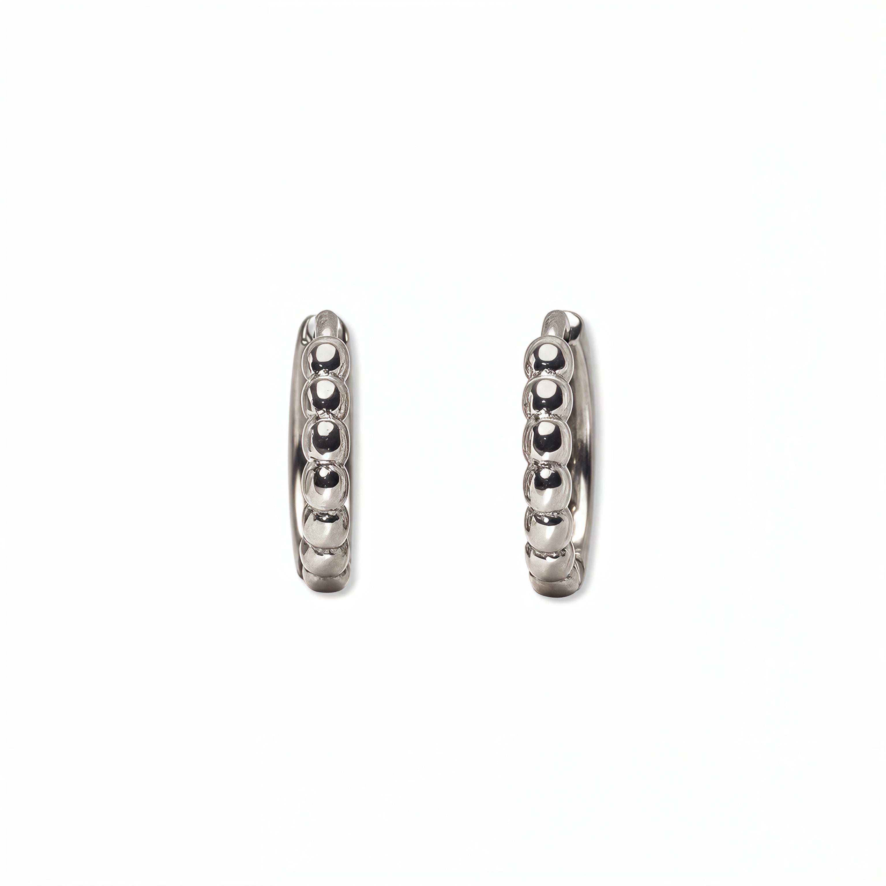 A pair of Beaded Huggie Hoop Earrings by Skōsh Jewelry, featuring small sterling silver huggie hoops with a beaded texture, displayed against a white background.