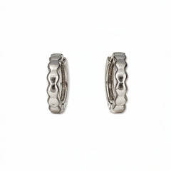 A pair of Hexagon Huggie Hoop Earrings by Skōsh Jewelry, featuring small sterling silver huggie hoops with a faceted hexagon texture, displayed against a white background.