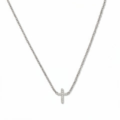 An Endless Faith Mini Cross with White Cubic Zirconia Necklace by Skōsh Jewelry, featuring a petite cross lined with small clear stones set on a fine sterling silver chain, displayed against a white background.