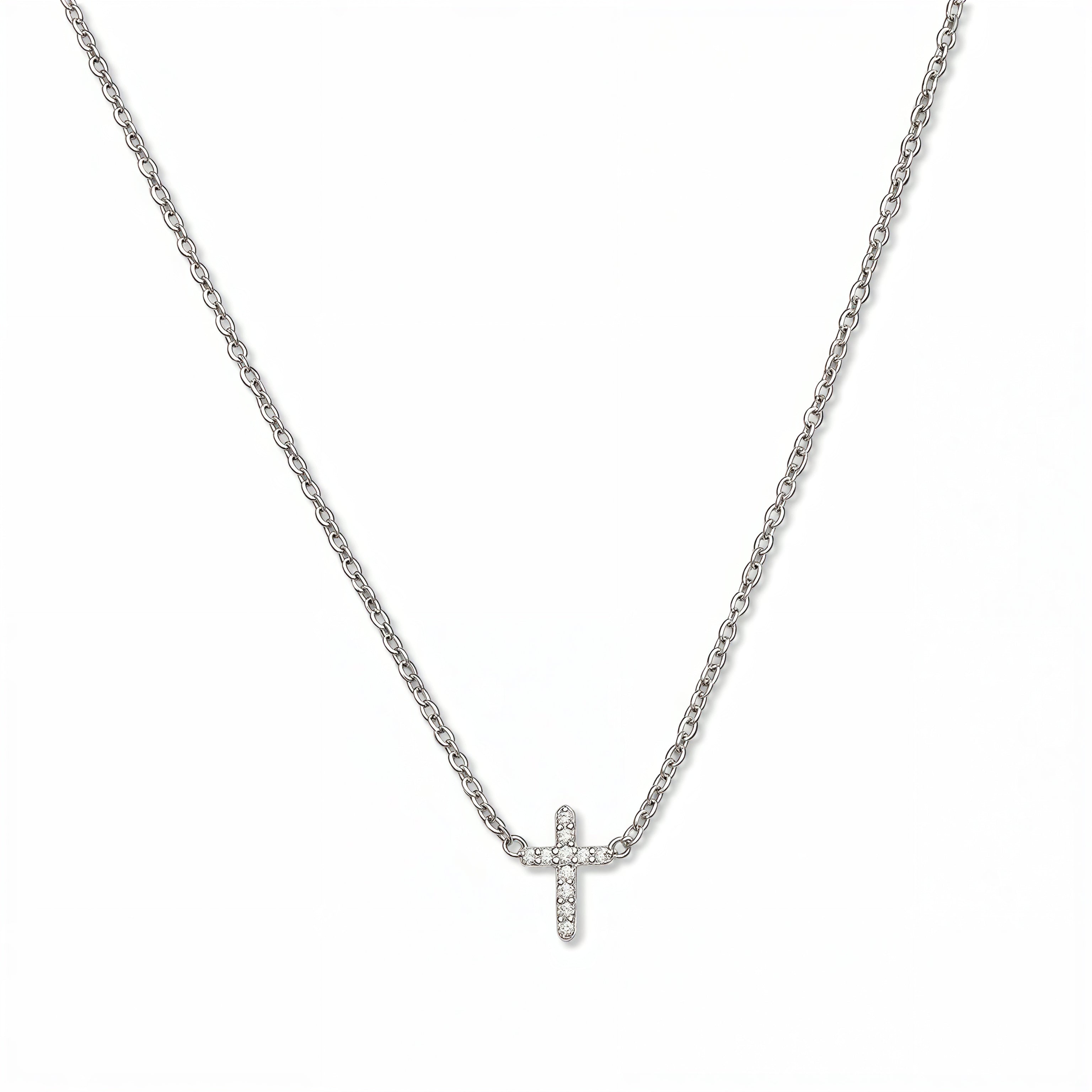 An Endless Faith Mini Cross with White Cubic Zirconia Necklace by Skōsh Jewelry, featuring a petite cross lined with small clear stones set on a fine sterling silver chain, displayed against a white background.