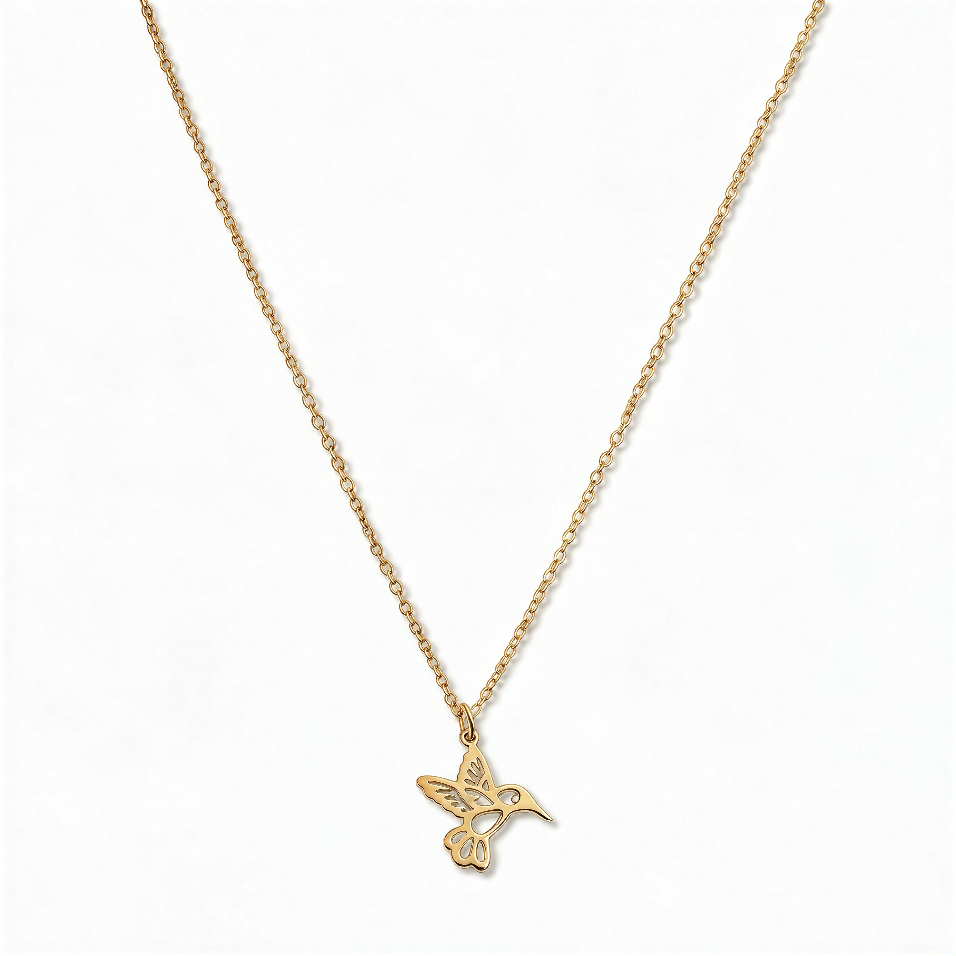 A Hummingbird Pendant Necklace by Skōsh Jewelry, featuring a small hummingbird in flight on a fine gold chain, displayed against a white background.