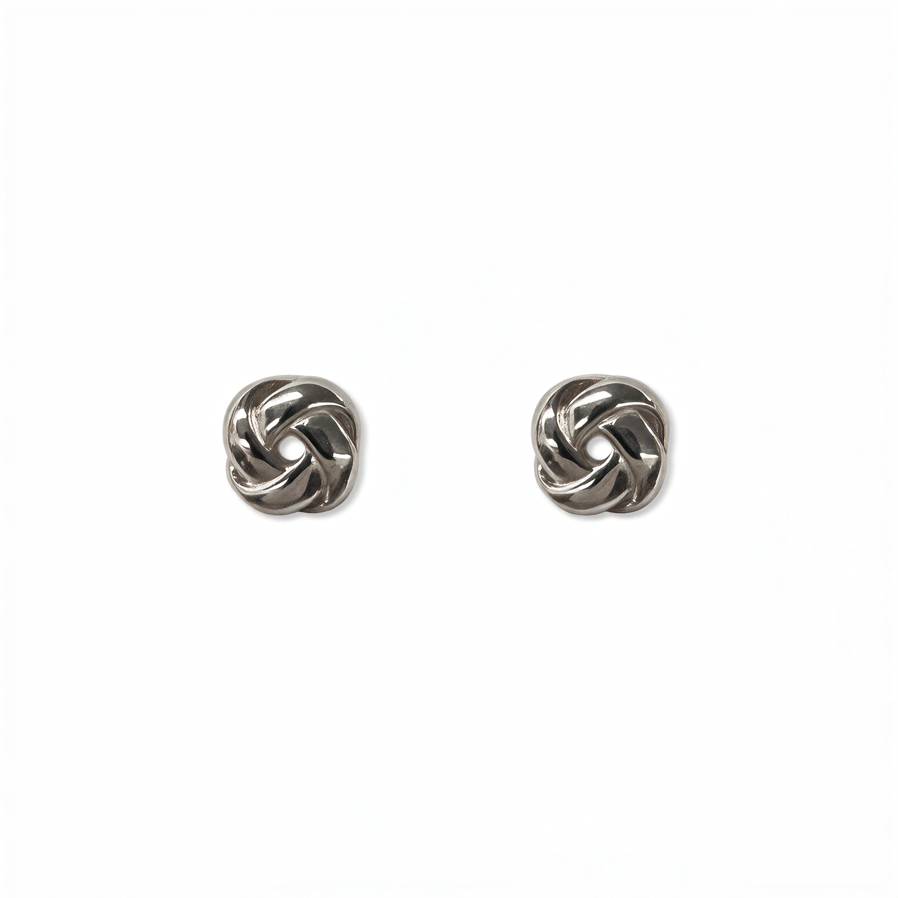 A pair of Knotted Stud Earrings by Skōsh Jewelry, featuring polished sterling silver studs shaped like twisted love knots, displayed against a white background.