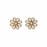A pair of Skōsh Kids Daisy Earrings by Skōsh Jewelry, featuring white enamel daisy flowers with yellow centers outlined in gold, displayed against a white background.