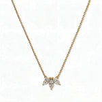 A Triple Marquise Cut White Cubic Zirconia Necklace by Skōsh Jewelry, featuring three marquise-cut clear stones fanned in a row on a fine gold chain, displayed against a white background.