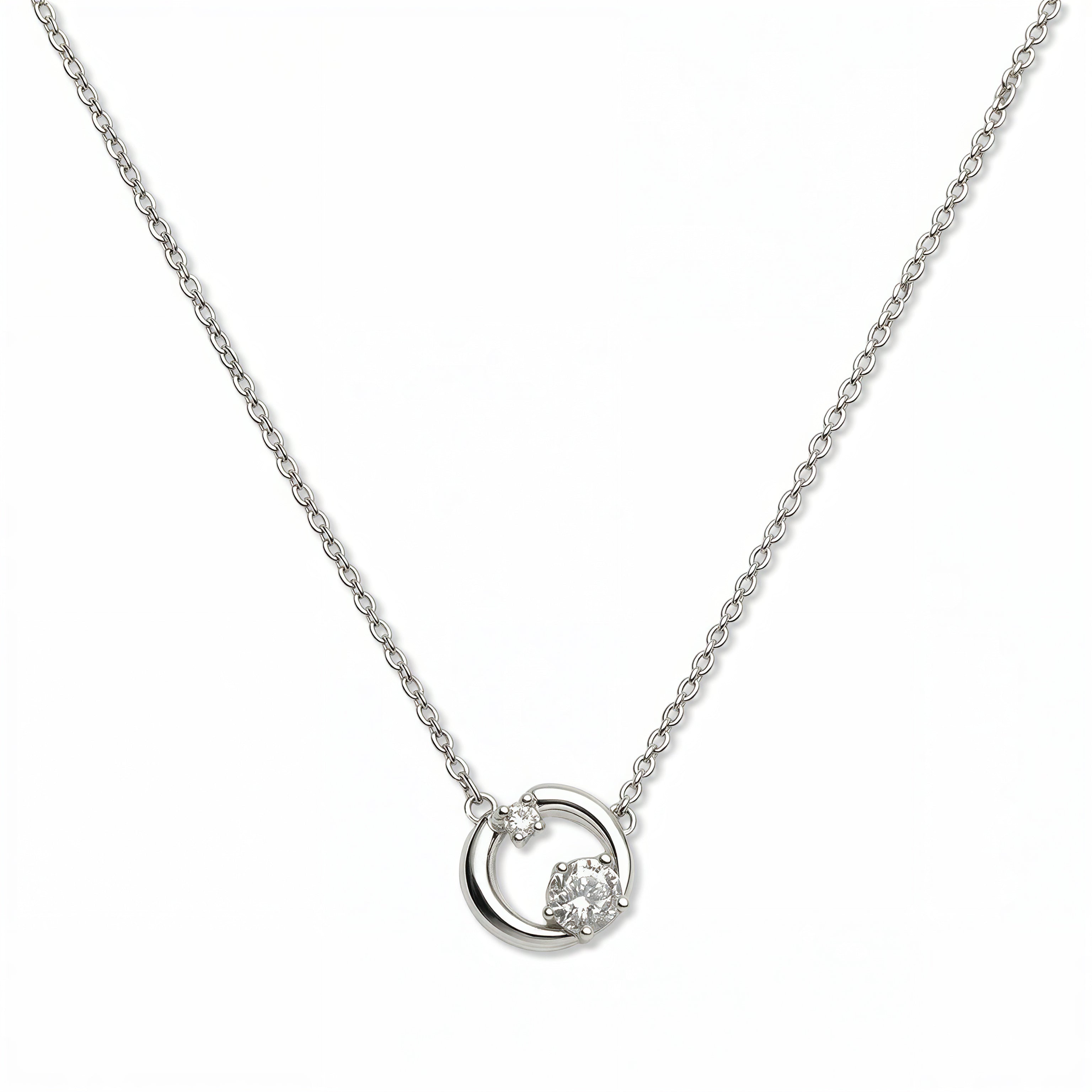 A Karma Double White Cubic Zirconia Accent Circle Necklace by Skōsh Jewelry, featuring an open circle with two clear stone accents on a fine sterling silver chain, displayed against a white background.