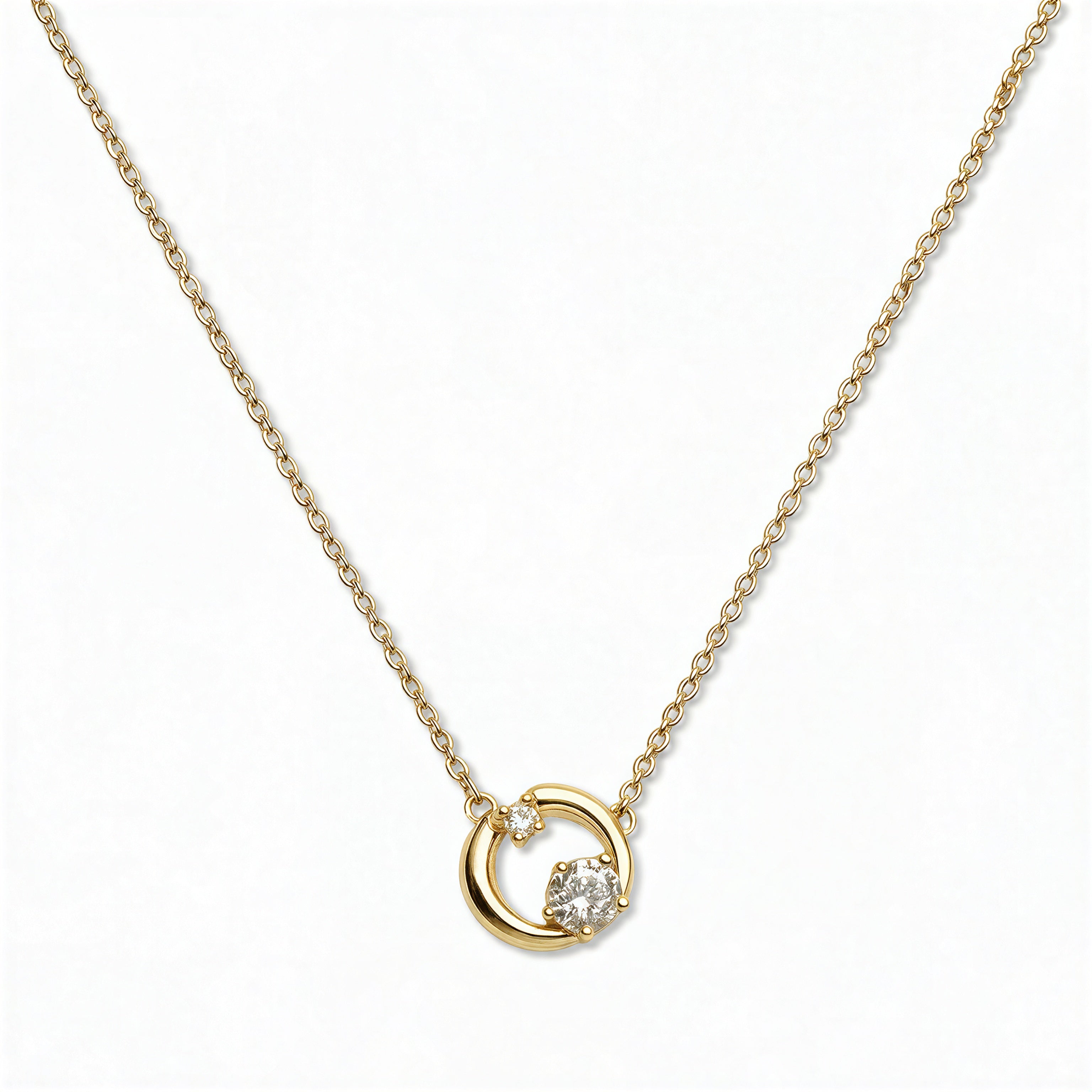 A Karma Double White Cubic Zirconia Accent Circle Necklace by Skōsh Jewelry, featuring an open circle with two clear stone accents on a fine gold chain, displayed against a white background.