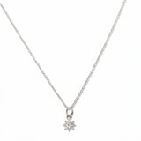 A Sunburst White Cubic Zirconia Pendant Necklace by Skōsh Jewelry, featuring a small sunburst pendant with a clear stone at its center on a fine sterling silver chain, displayed against a white background.