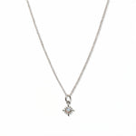 A Sunburst Opal Pendant Necklace by Skōsh Jewelry, featuring a tiny sunburst pendant with an opal center on a fine sterling silver chain, displayed against a white background.