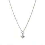 A Sunburst Opal Pendant Necklace by Skōsh Jewelry, featuring a tiny sunburst pendant with an opal center on a fine sterling silver chain, displayed against a white background.