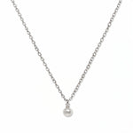 A Classic Drop Pearl with White Cubic Zirconia Accent Necklace by Skōsh Jewelry, featuring a round white freshwater pearl drop topped with a small clear stone on a fine sterling silver chain, displayed against a white background.
