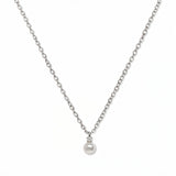 A Classic Drop Pearl with White Cubic Zirconia Accent Necklace by Skōsh Jewelry, featuring a round white freshwater pearl drop topped with a small clear stone on a fine sterling silver chain, displayed against a white background.