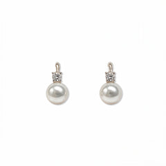 A pair of Classic Pearl with White Cubic Zirconia Accent Earrings by Skōsh Jewelry, featuring round white freshwater pearl drops topped with small clear stones in sterling silver, displayed against a white background.