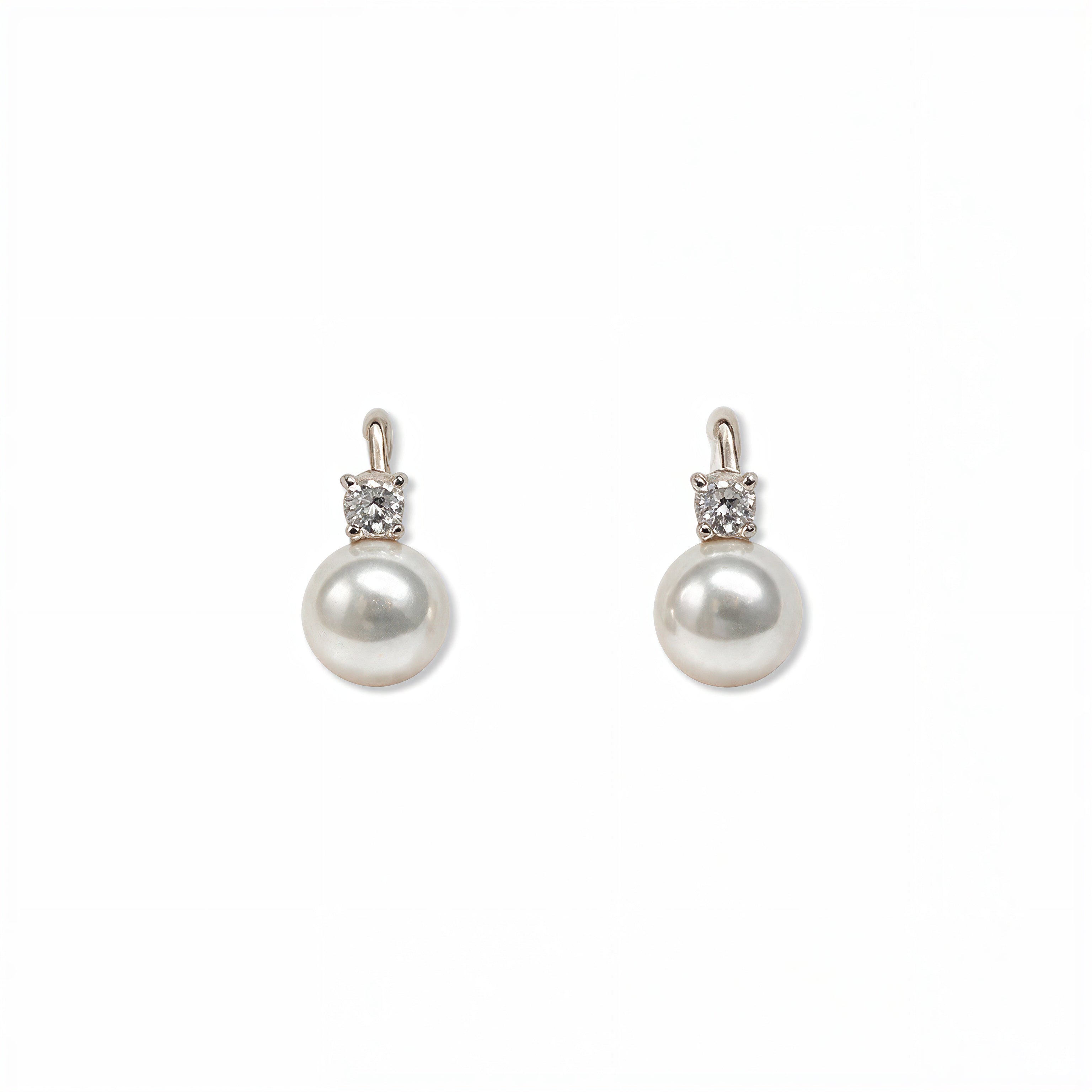 A pair of Classic Pearl with White Cubic Zirconia Accent Earrings by Skōsh Jewelry, featuring round white freshwater pearl drops topped with small clear stones in sterling silver, displayed against a white background.