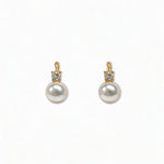 A pair of Classic Pearl with White Cubic Zirconia Accent Earrings by Skōsh Jewelry, featuring round white freshwater pearl drops topped with small clear stones in gold, displayed against a white background.