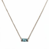A March Birthstone Light Sapphire Cubic Zirconia Baguette Necklace by Skōsh Jewelry, featuring a slim rectangular light blue baguette stone set horizontally on a fine sterling silver chain, displayed against a white background.