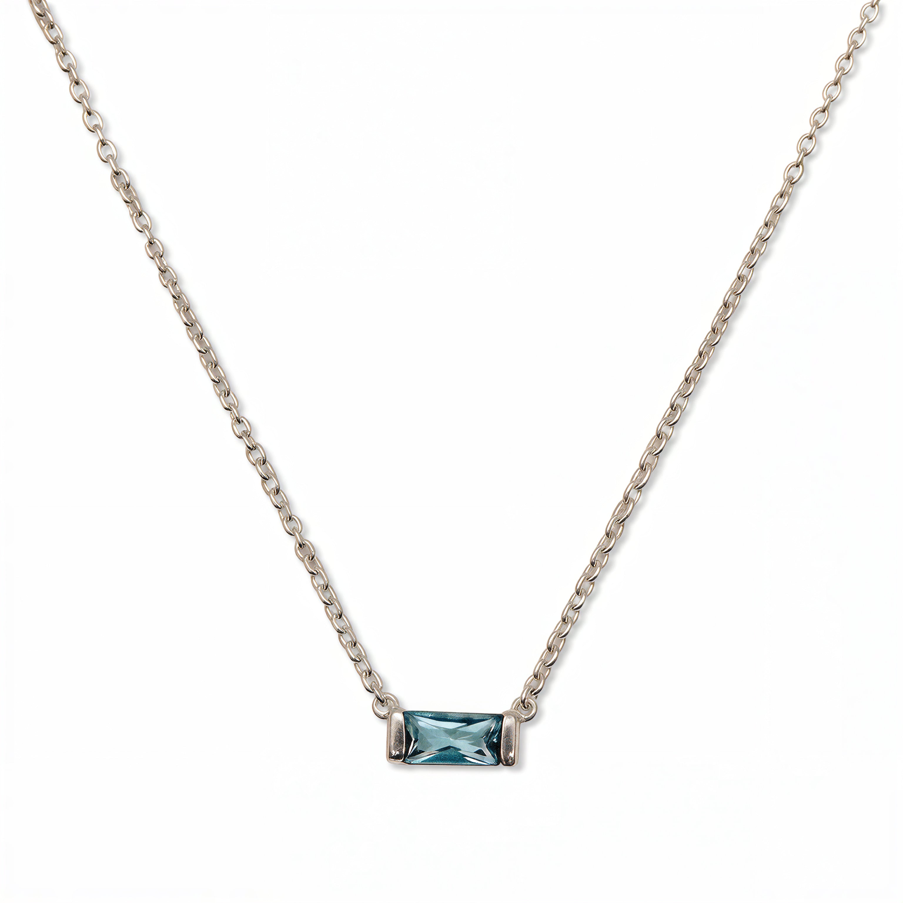A March Birthstone Light Sapphire Cubic Zirconia Baguette Necklace by Skōsh Jewelry, featuring a slim rectangular light blue baguette stone set horizontally on a fine sterling silver chain, displayed against a white background.