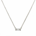 An April Birthstone White Cubic Zirconia Baguette Necklace by Skōsh Jewelry, featuring a slim rectangular clear baguette stone set horizontally on a fine sterling silver chain, displayed against a white background.