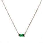 A May Birthstone Emerald Cubic Zirconia Baguette Necklace by Skōsh Jewelry, featuring a slim rectangular green baguette stone set horizontally on a fine sterling silver chain, displayed against a white background.