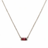 A July Birthstone Ruby Cubic Zirconia Baguette Necklace by Skōsh Jewelry, featuring a slim rectangular red baguette stone set horizontally on a fine sterling silver chain, displayed against a white background.