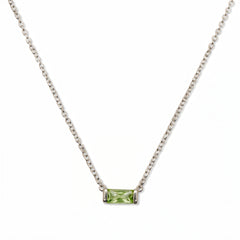 An August Birthstone Peridot Cubic Zirconia Baguette Necklace by Skōsh Jewelry, featuring a slim rectangular light green baguette stone set horizontally on a fine sterling silver chain, displayed against a white background.
