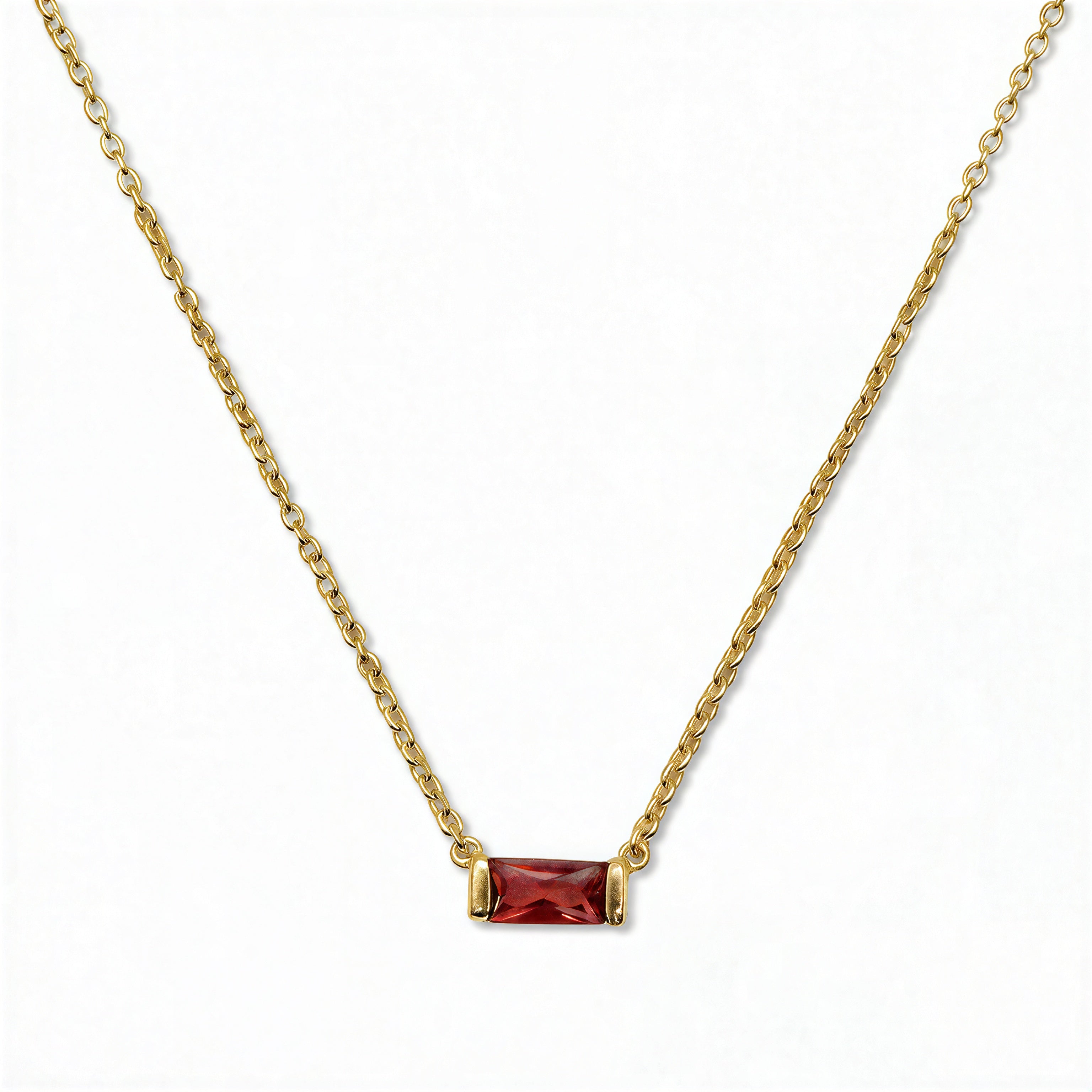 A January Birthstone Garnet Cubic Zirconia Baguette Necklace by Skōsh Jewelry, featuring a slim rectangular deep red baguette stone set horizontally on a fine gold chain, displayed against a white background.