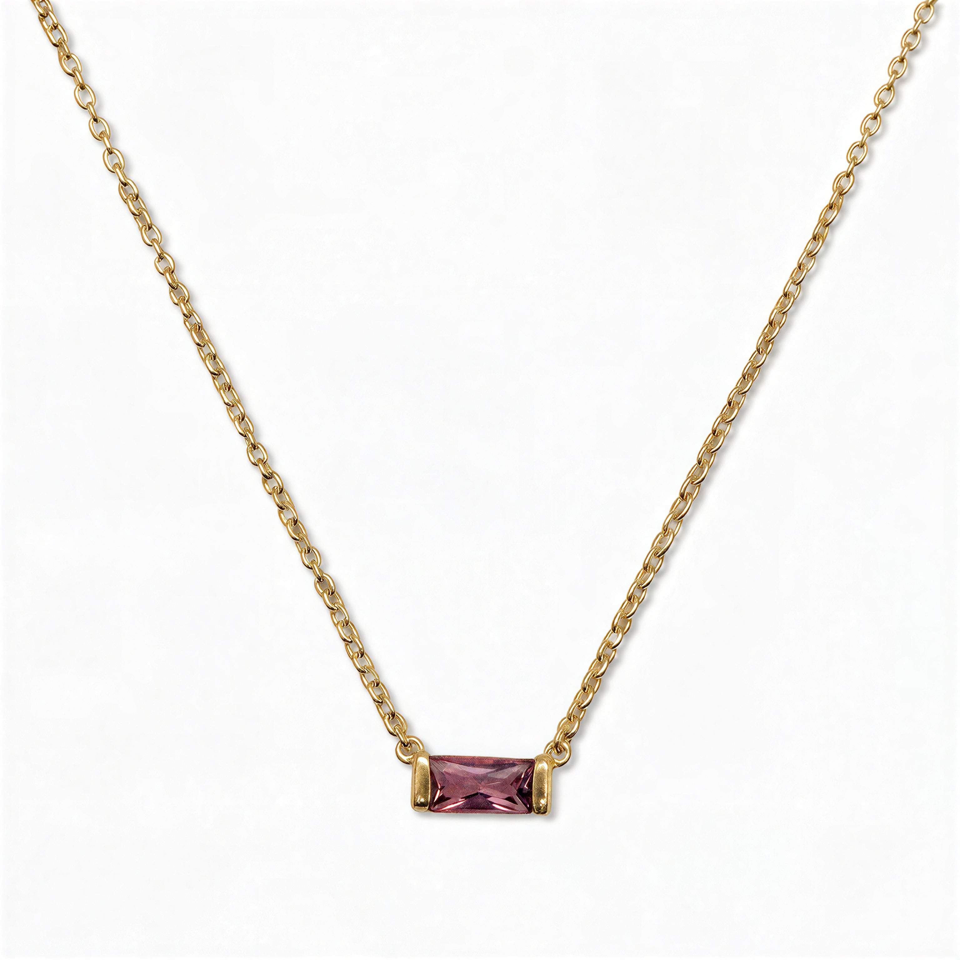 A February Birthstone Amethyst Cubic Zirconia Baguette Necklace by Skōsh Jewelry, featuring a slim rectangular purple baguette stone set horizontally on a fine gold chain, displayed against a white background.