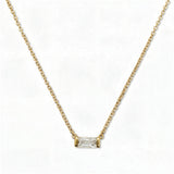 An April Birthstone White Cubic Zirconia Baguette Necklace by Skōsh Jewelry, featuring a slim rectangular clear baguette stone set horizontally on a fine gold chain, displayed against a white background.