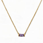 A June Birthstone Lavender Cubic Zirconia Baguette Necklace by Skōsh Jewelry, featuring a slim rectangular light purple baguette stone set horizontally on a fine gold chain, displayed against a white background.
