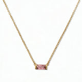An October Birthstone Pink Cubic Zirconia Baguette Necklace by Skōsh Jewelry, featuring a slim rectangular pink baguette stone set horizontally on a fine gold chain, displayed against a white background.