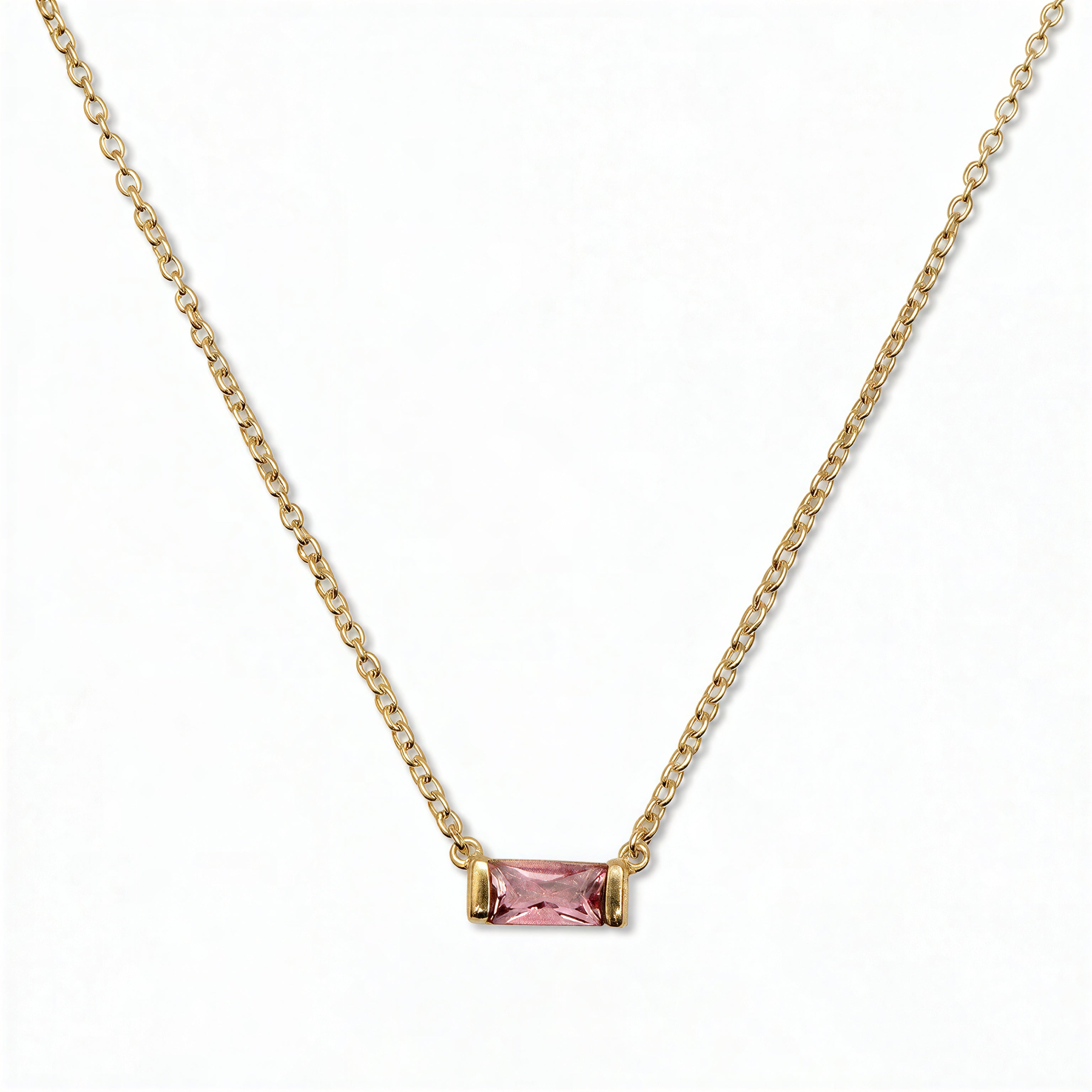 An October Birthstone Pink Cubic Zirconia Baguette Necklace by Skōsh Jewelry, featuring a slim rectangular pink baguette stone set horizontally on a fine gold chain, displayed against a white background.