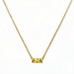 A November Birthstone Citrine Cubic Zirconia Baguette Necklace by Skōsh Jewelry, featuring a slim rectangular yellow baguette stone set horizontally on a fine gold chain, displayed against a white background.