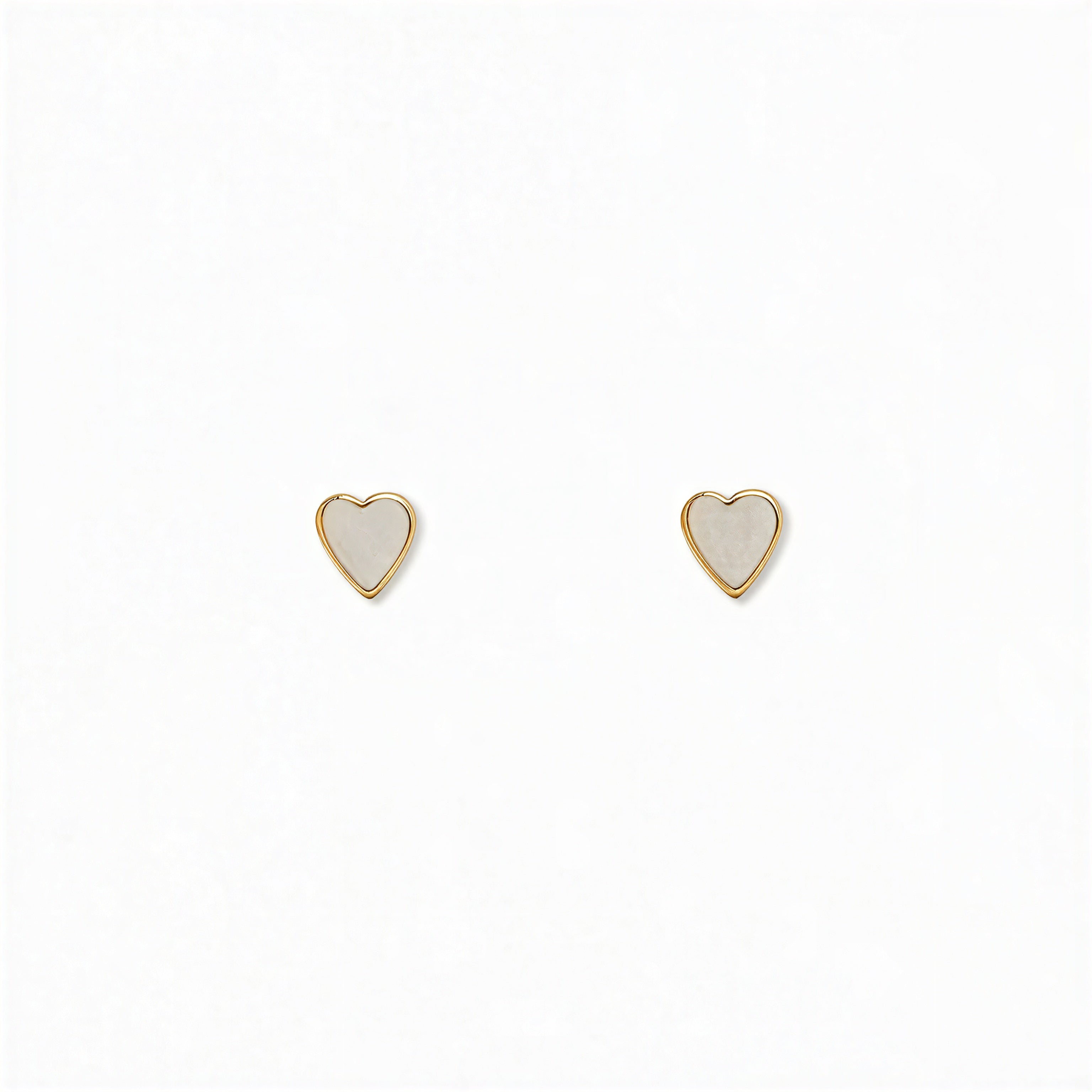 A pair of Polished Mini Heart Stud Earrings by Skōsh Jewelry, featuring tiny heart-shaped studs in gold, displayed against a white background.