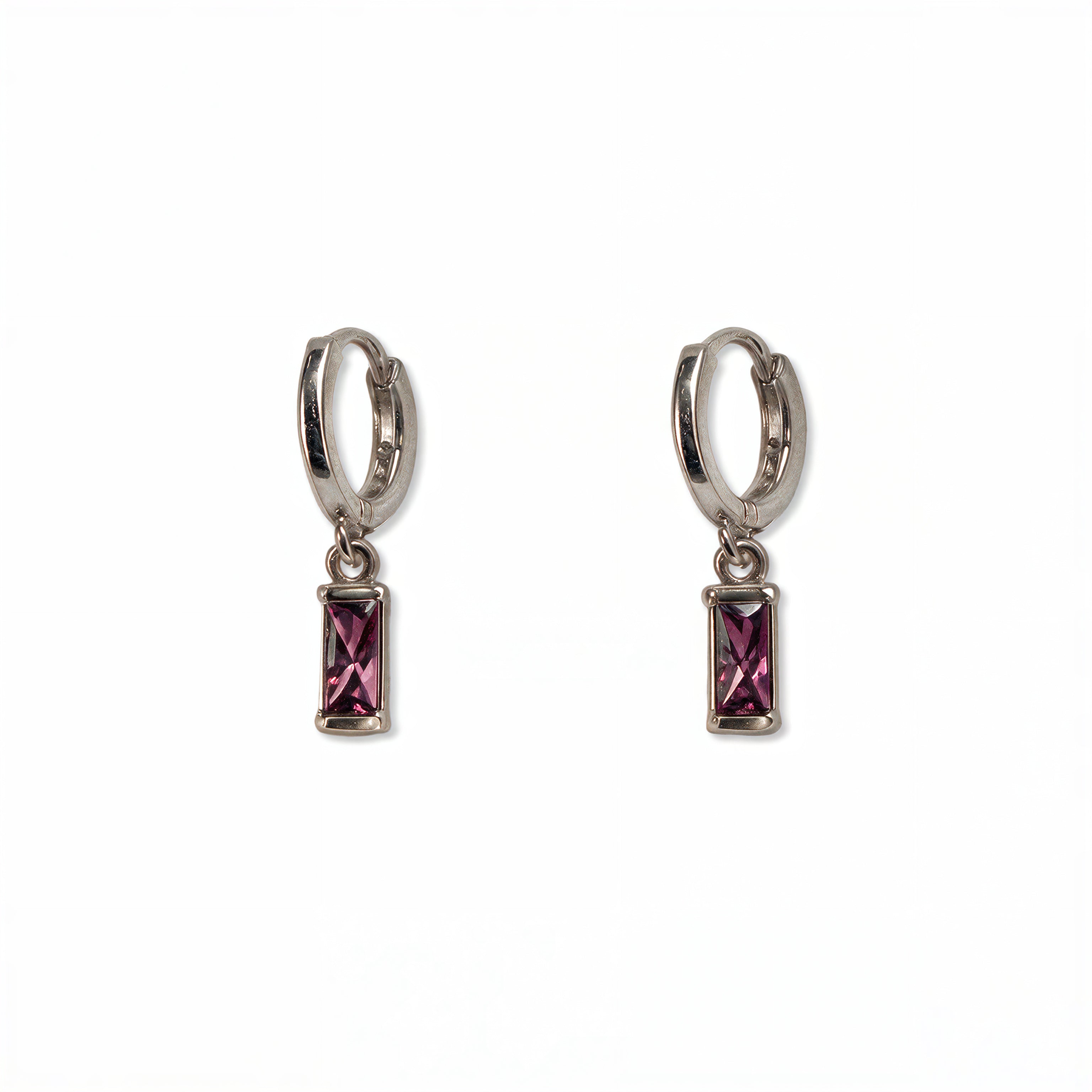 A pair of February Birthstone Amethyst Cubic Zirconia Baguette Earrings by Skōsh Jewelry, featuring small sterling silver huggie hoops, each with a rectangular purple baguette stone dangling below, displayed against a white background.