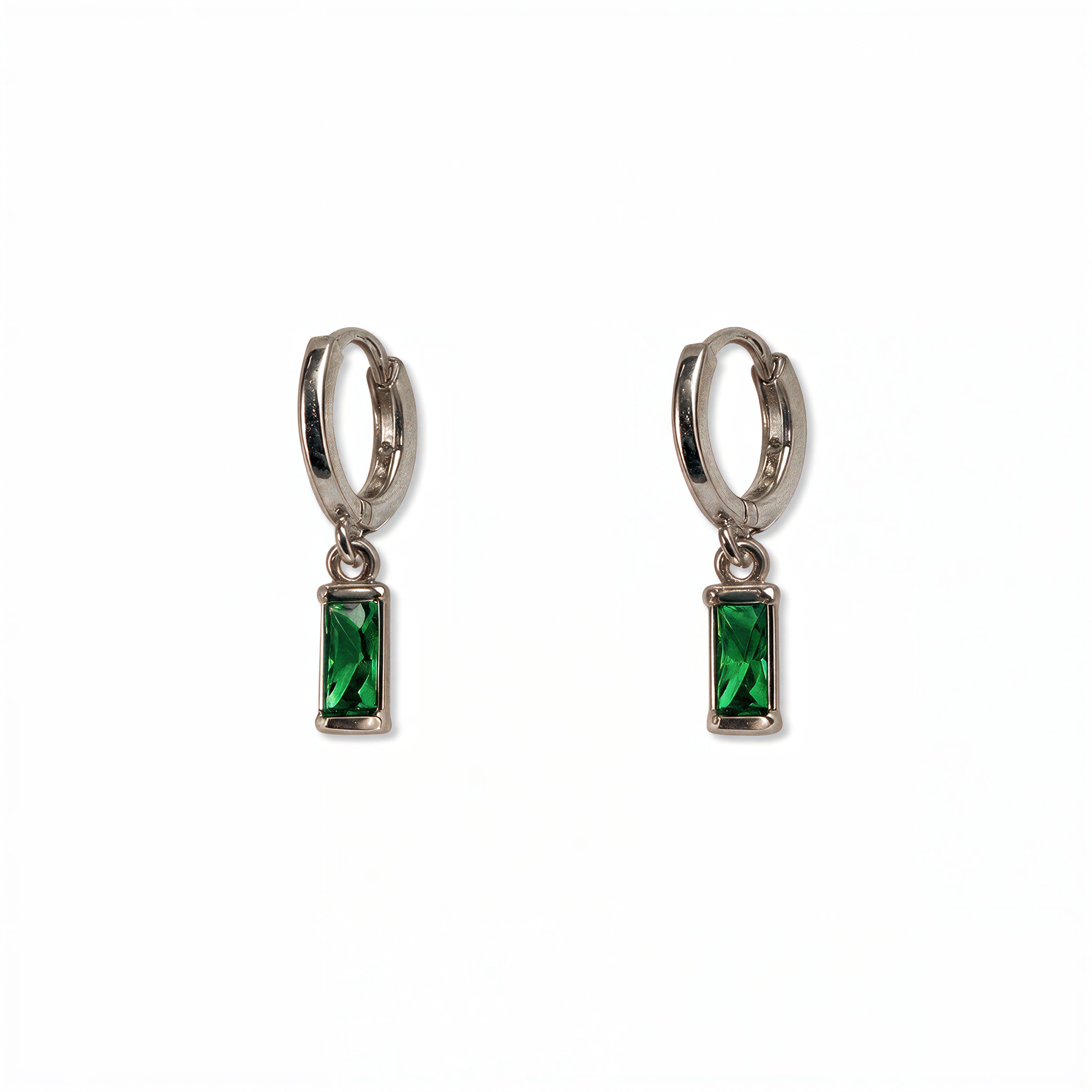 A pair of May Birthstone Emerald Cubic Zirconia Baguette Earrings by Skōsh Jewelry, featuring small sterling silver huggie hoops, each with a rectangular green baguette stone dangling below, displayed against a white background.