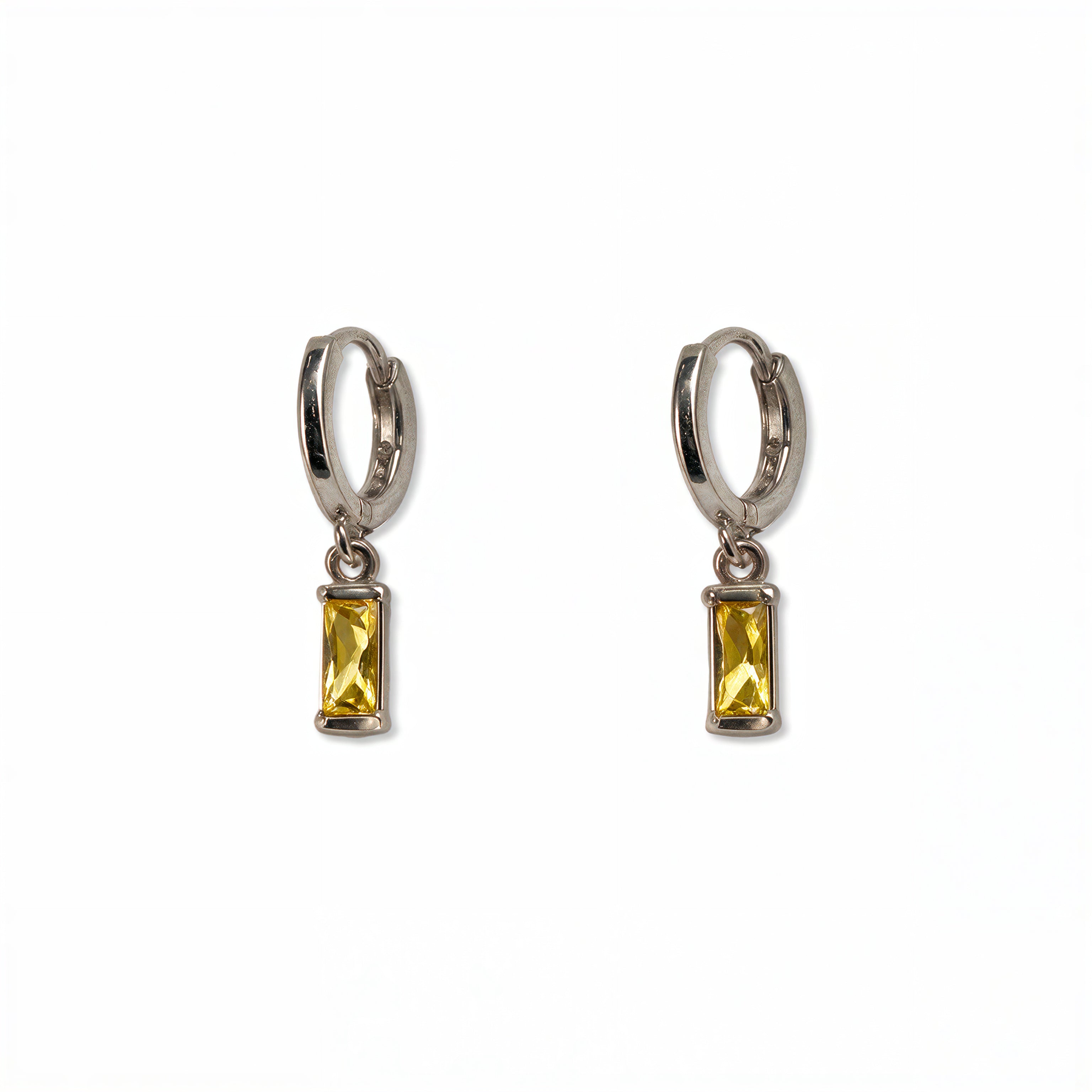 A pair of November Birthstone Citrine Cubic Zirconia Baguette Earrings by Skōsh Jewelry, featuring small sterling silver huggie hoops, each with a rectangular yellow baguette stone dangling below, displayed against a white background.