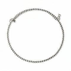 A Glint 2mm Beaded Coil Bracelet by Skōsh Jewelry, featuring a coil of small, polished 2mm sterling silver beads wrapped in a spiral, displayed against a white background.