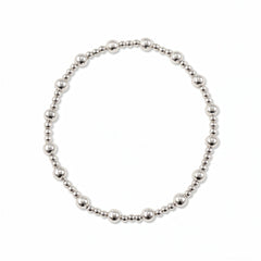 A Duo 2mm/4mm Beaded Stretch Bracelet by Skōsh Jewelry, featuring a strand of alternating 2mm and 4mm polished sterling silver beads on a stretch cord, displayed against a white background.