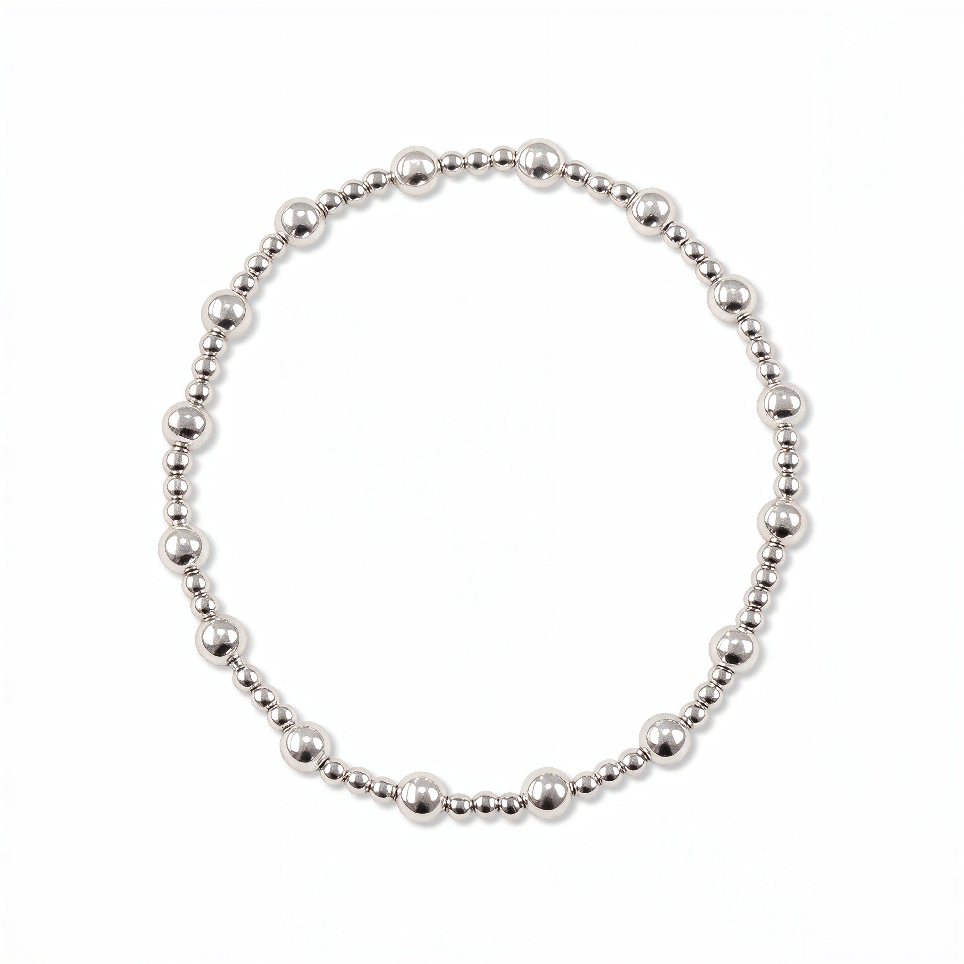 A Duo 2mm/4mm Beaded Stretch Bracelet by Skōsh Jewelry, featuring a strand of alternating 2mm and 4mm polished sterling silver beads on a stretch cord, displayed against a white background.