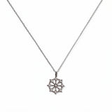 A Snowflake Pendant with White Cubic Zirconia Accent Necklace by Skōsh Jewelry, featuring a snowflake pendant accented with small clear stones on a fine sterling silver chain, displayed against a white background.